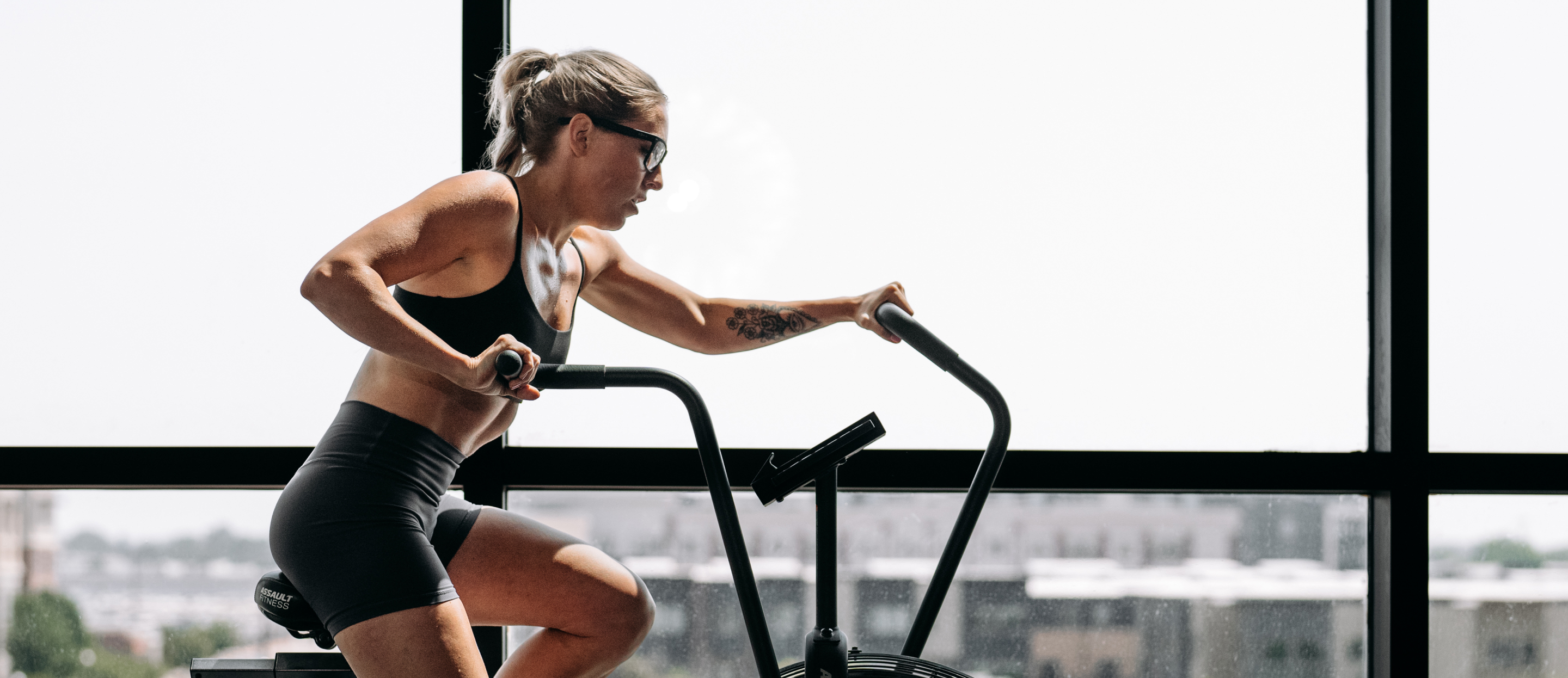 Woman on stationary bike wearing Barton eyeglasses