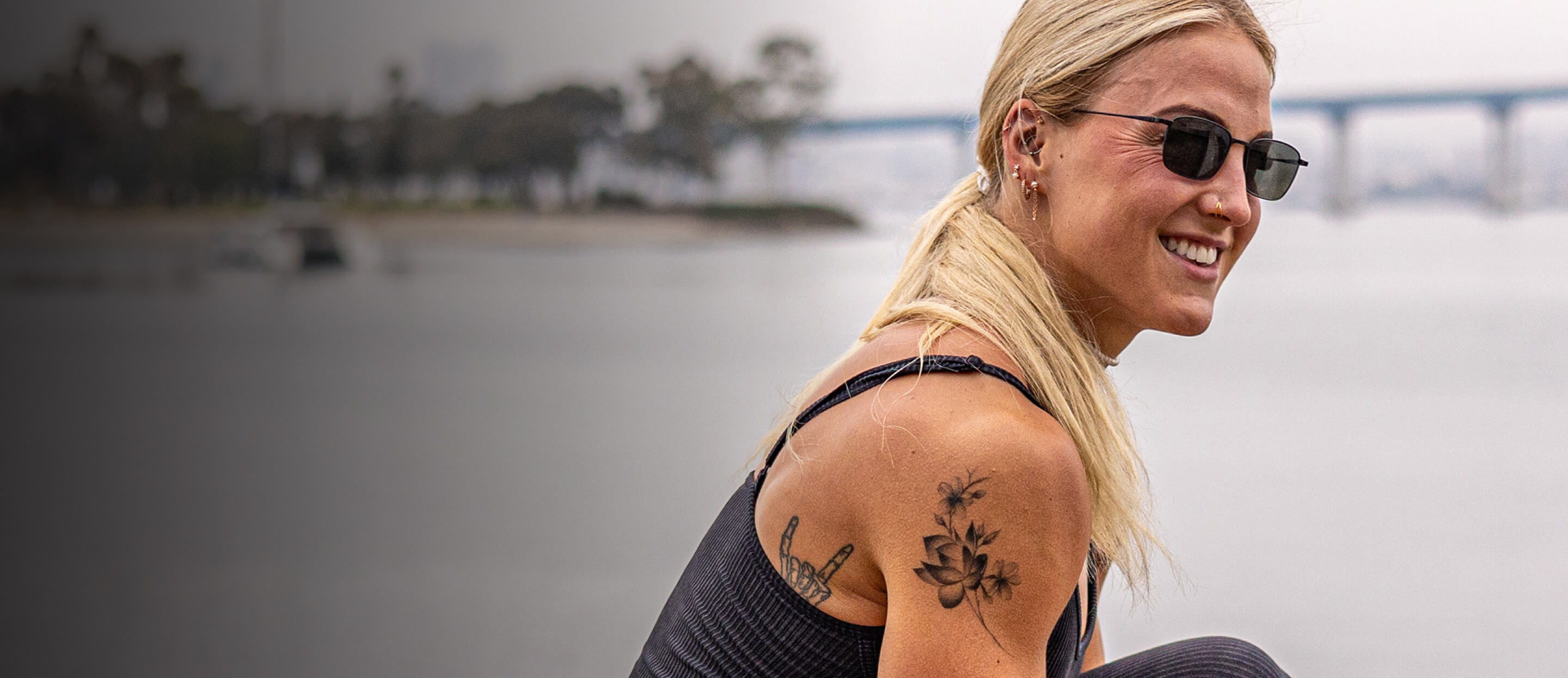 Woman smiling by ocean in Vapor sunglasses