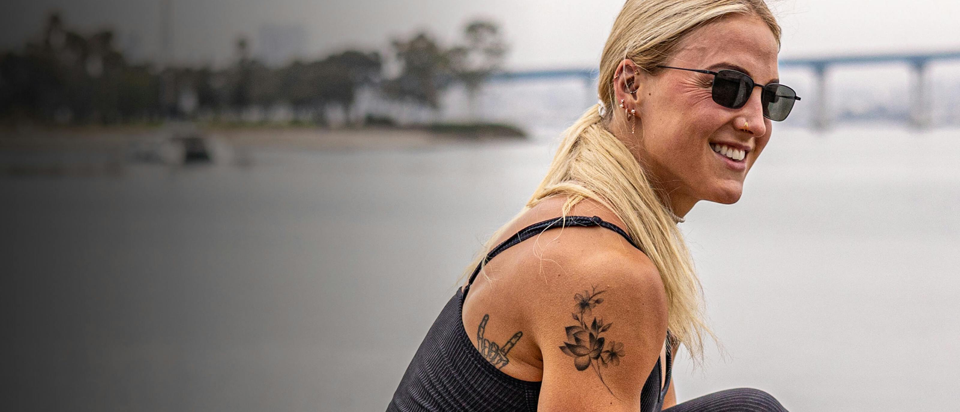 Woman smiling by ocean in Vapor sunglasses