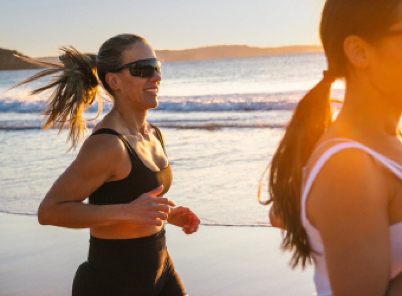 Woman jogging on beach wearing CP-1x sunglasses