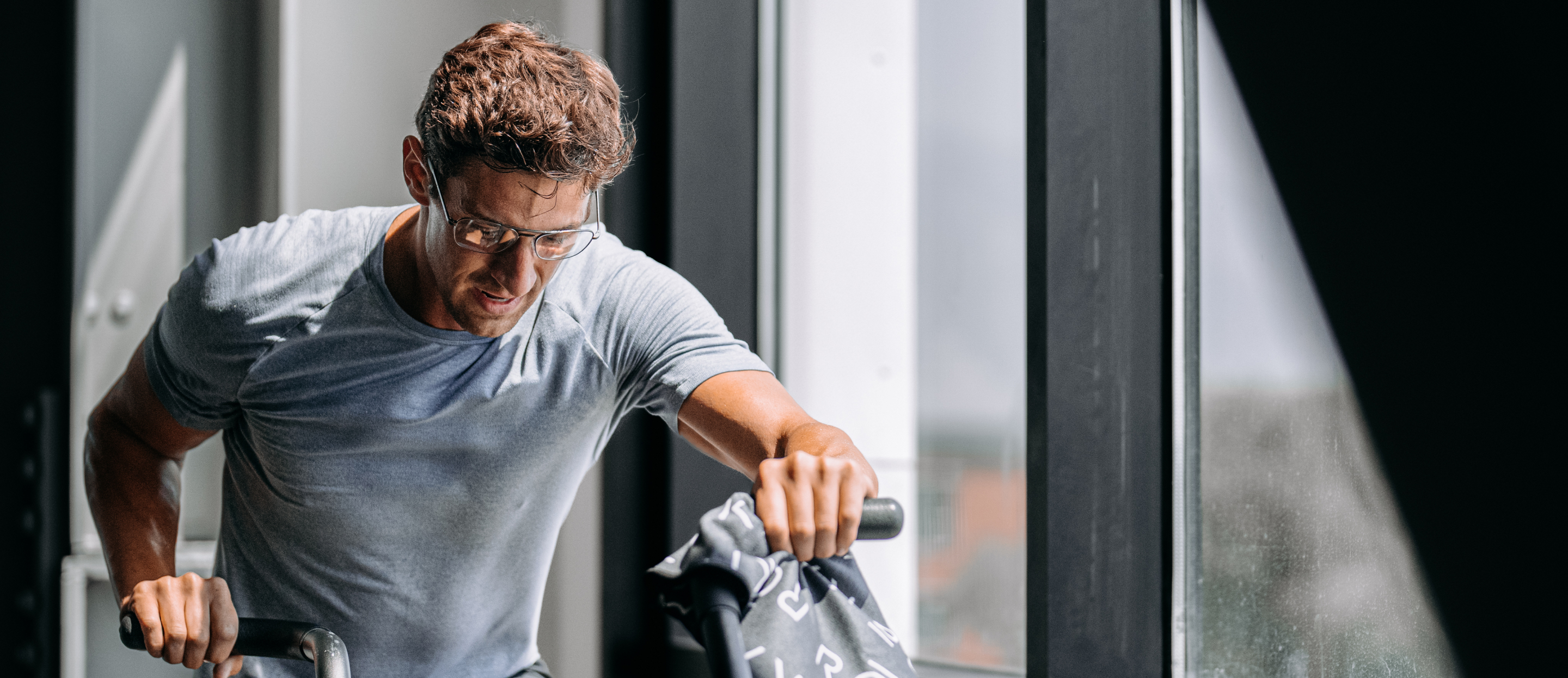Man riding assault bike wearing Falcon eyeglasses