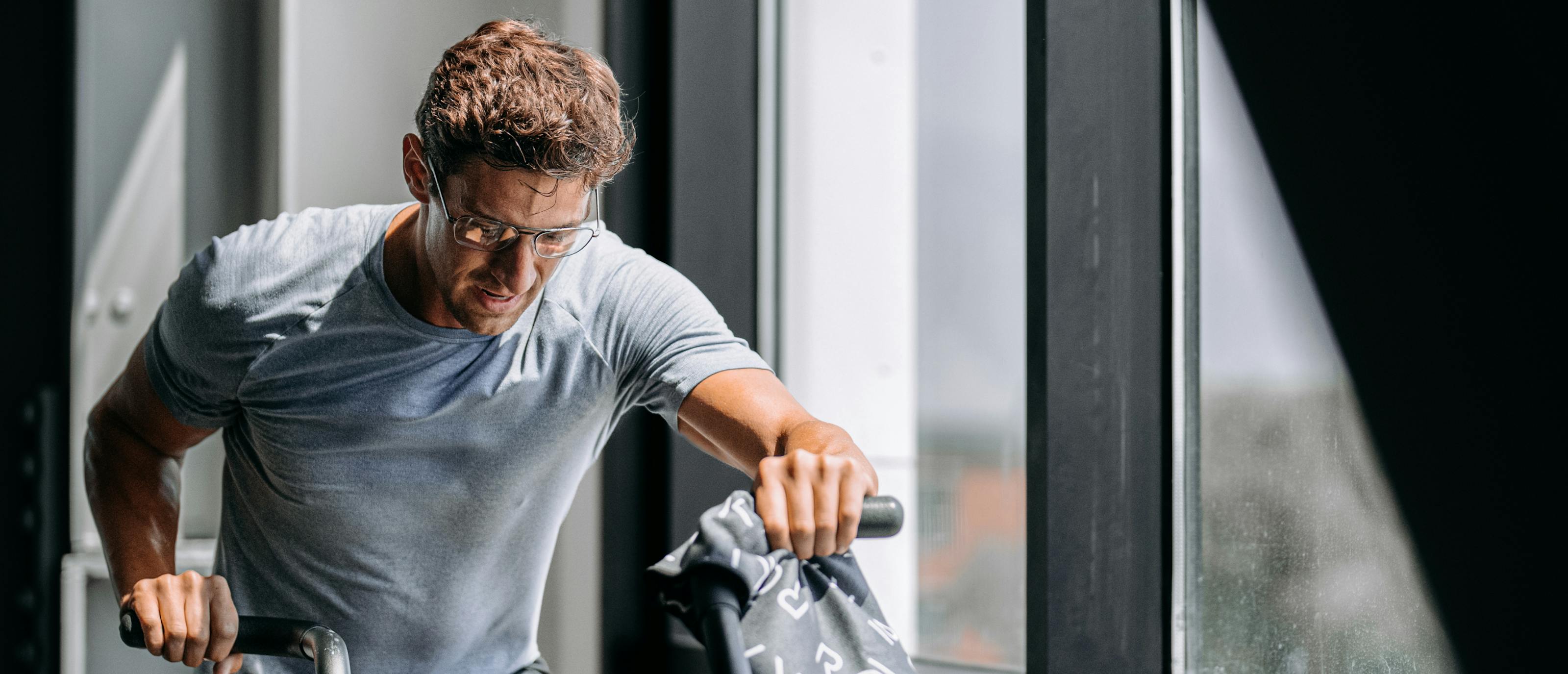 Man riding assault bike wearing Falcon eyeglasses
