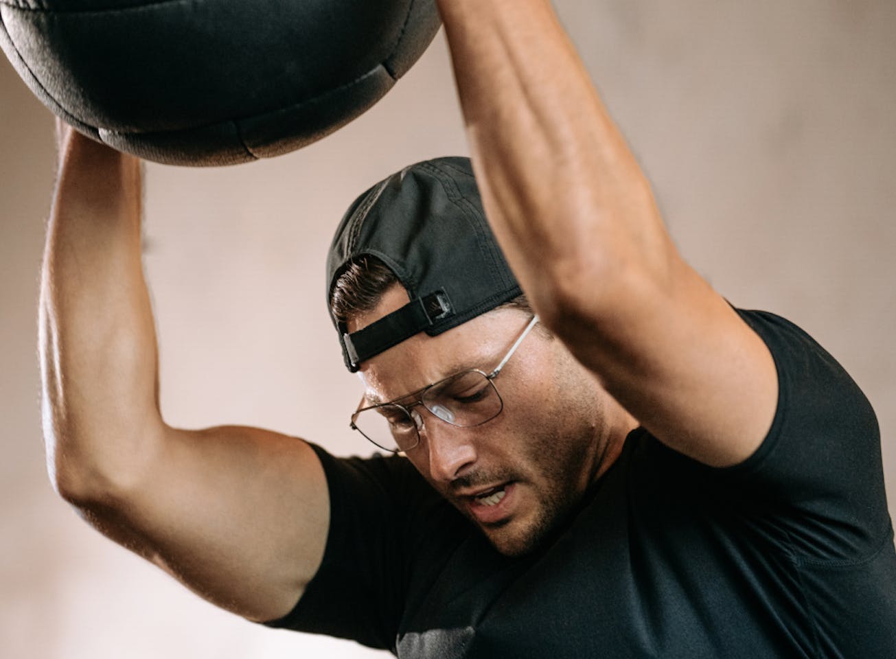Man throwing medicine ball wearing Falcon eyeglasses