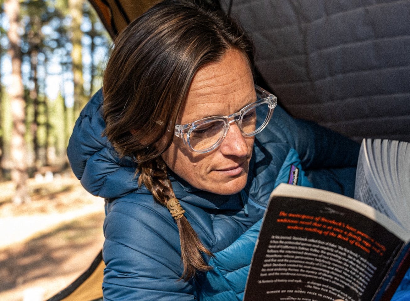 Woman in tent reading where Cooper Eyeglasses