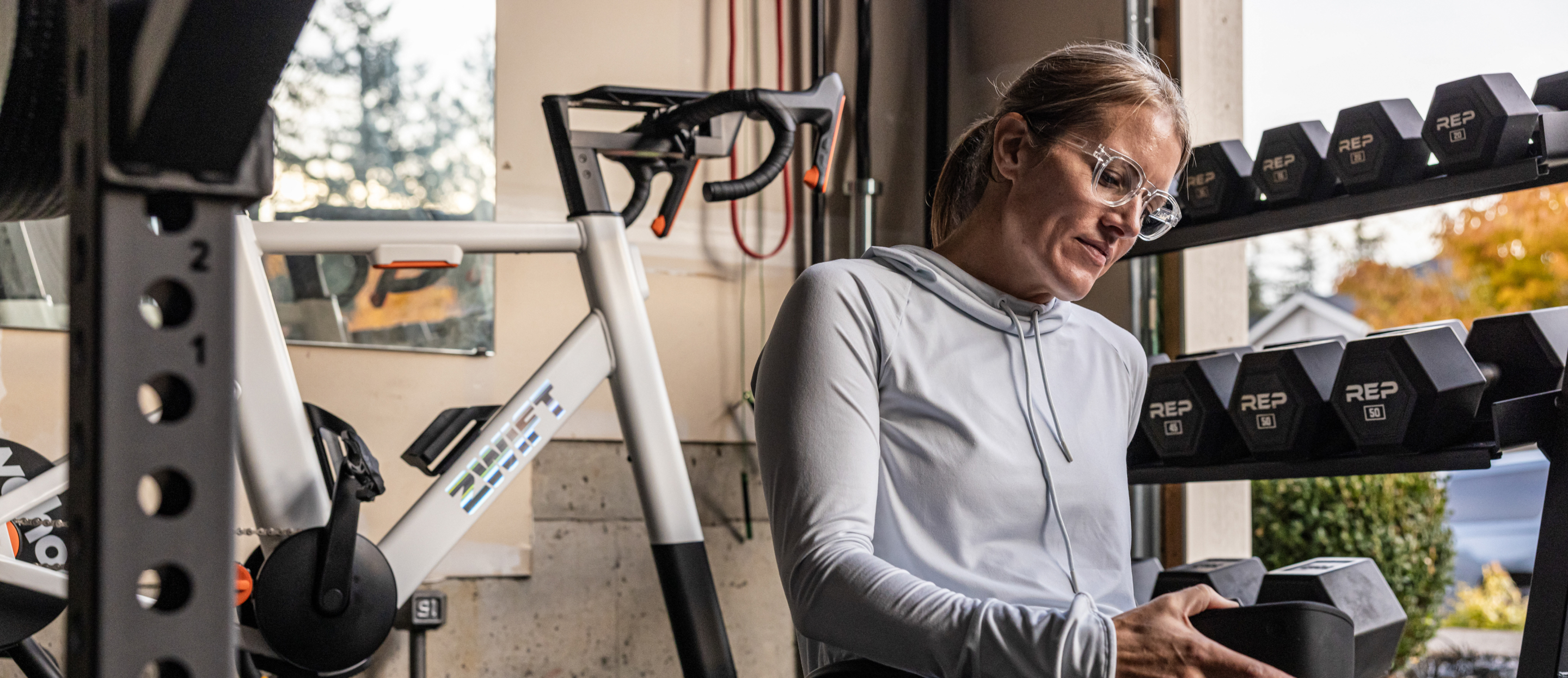 Woman grabbing dumbbell wearing Jackson eyeglasses