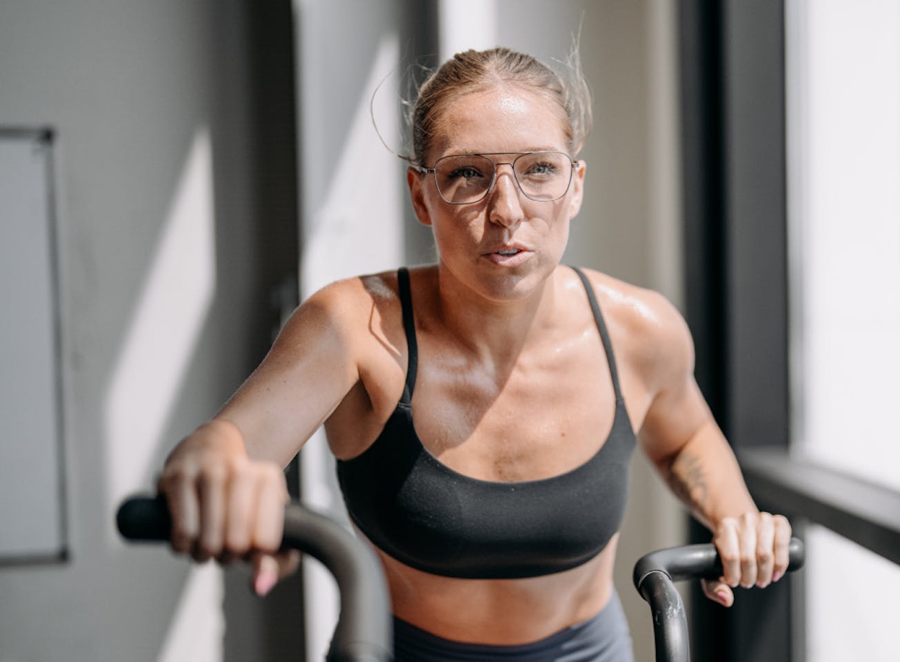 Woman riding assault bike wearing Falcon eyeglasses