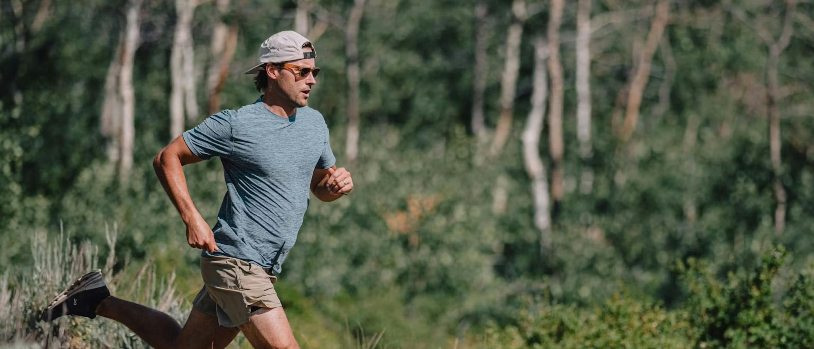 Man running in woods wearing Mayfield glasses