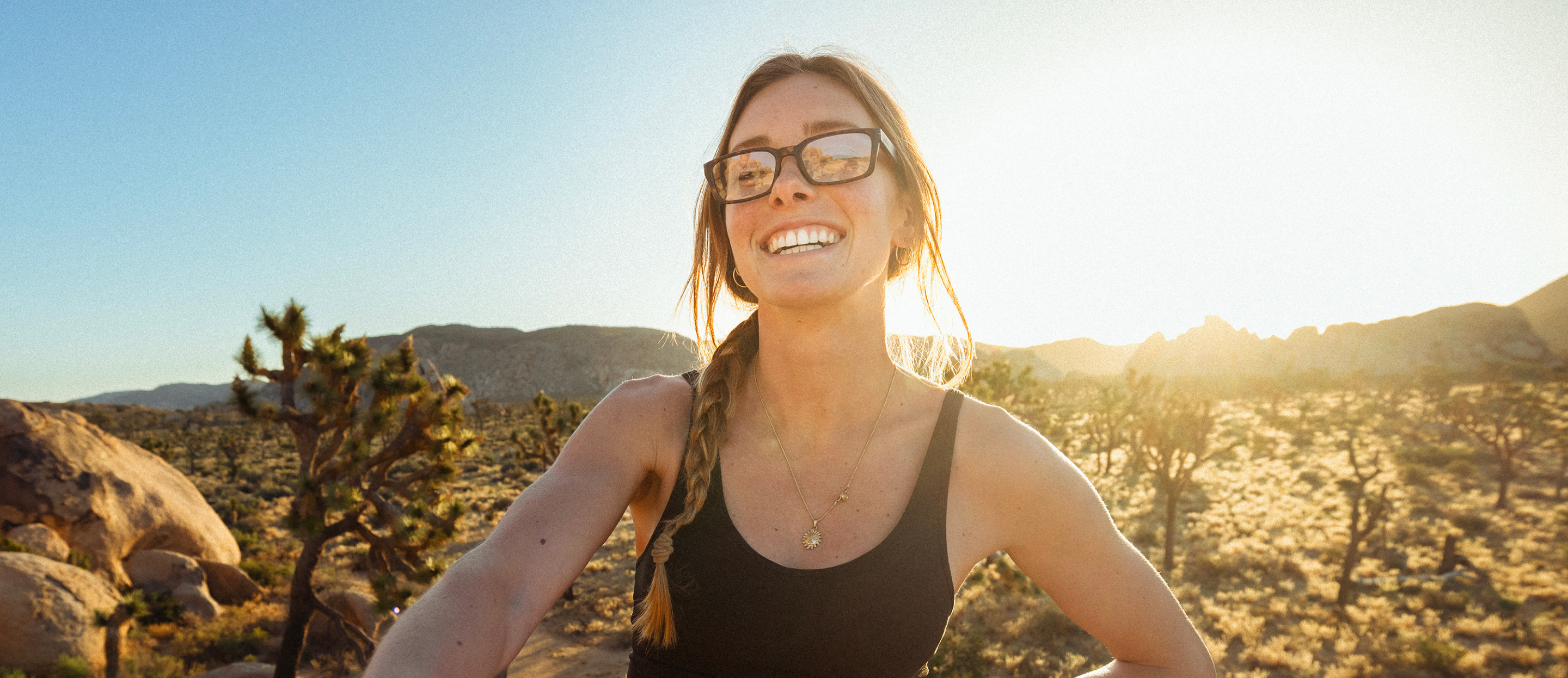 Woman smiling in desert wearing Mayfield eyeglasses