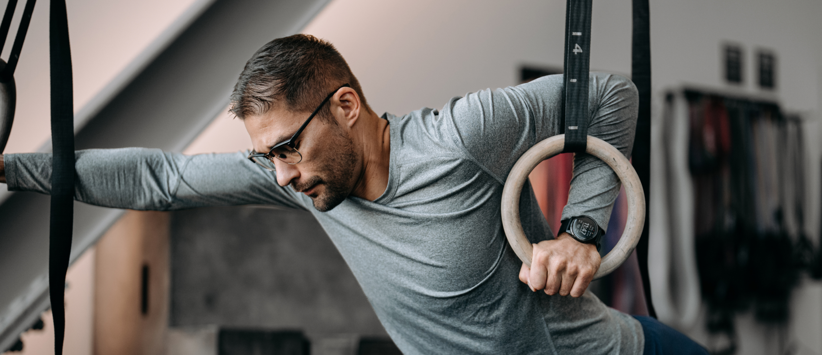 Man doing muscle up wearing Cambridge glasses