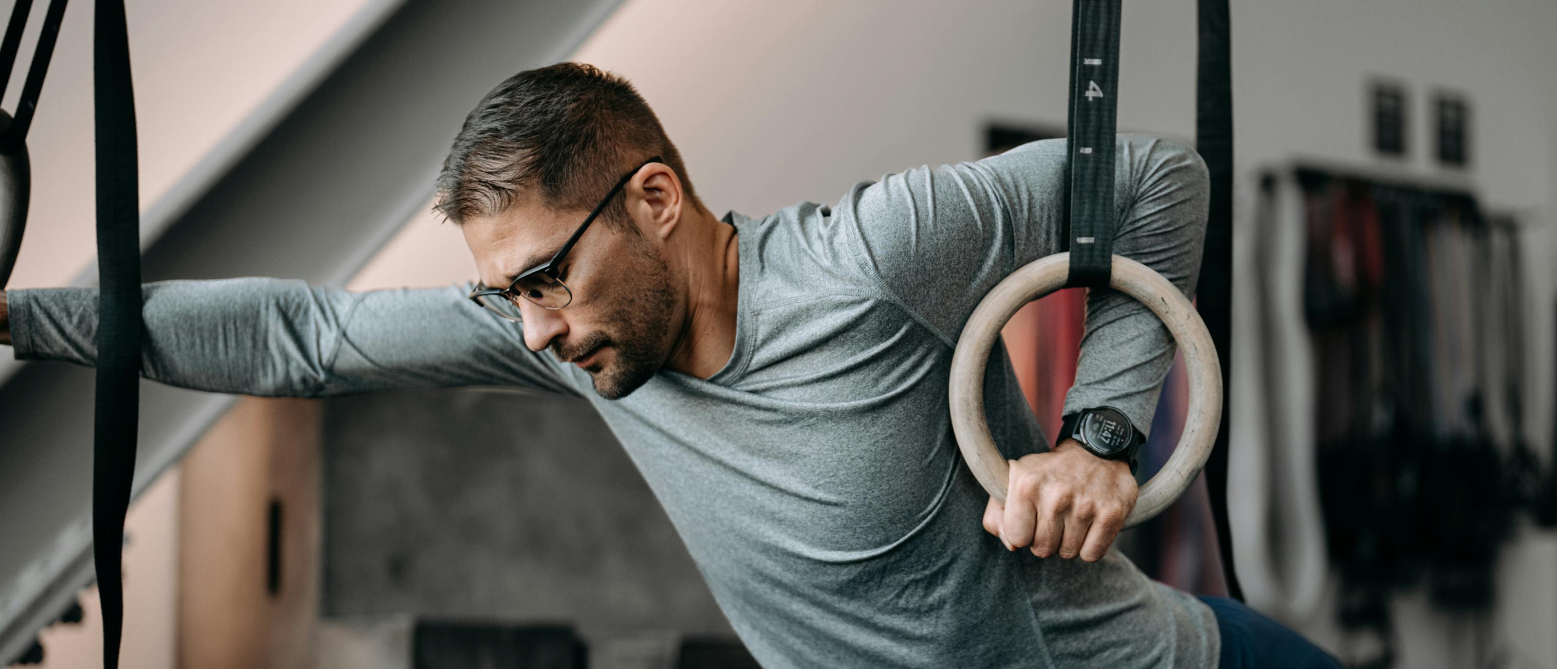 Man doing muscle up wearing Cambridge glasses