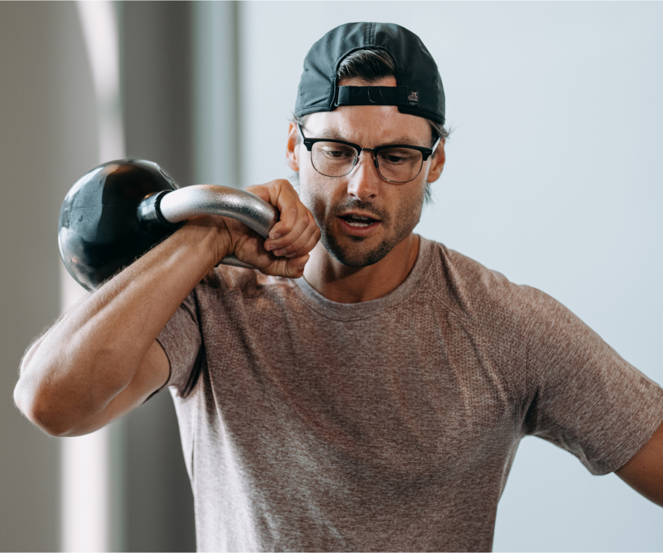 Man doing kettlebell workout wearing Cambridge eyeglasses