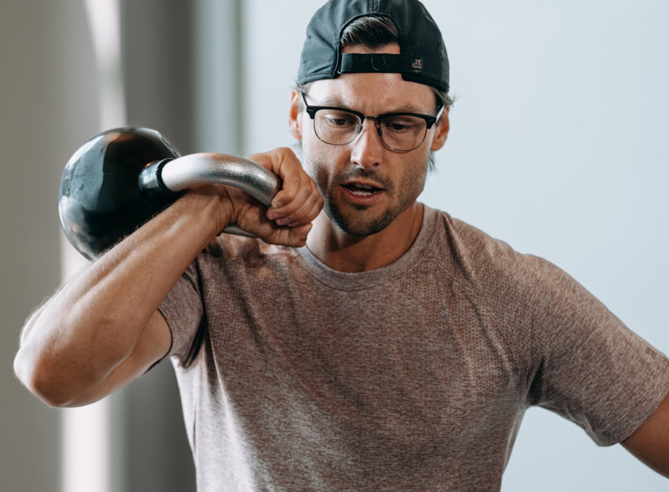 Man doing kettlebell workout wearing Cambridge eyeglasses