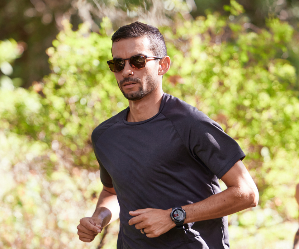 Man jogging in woods wearing Cade sunglasses