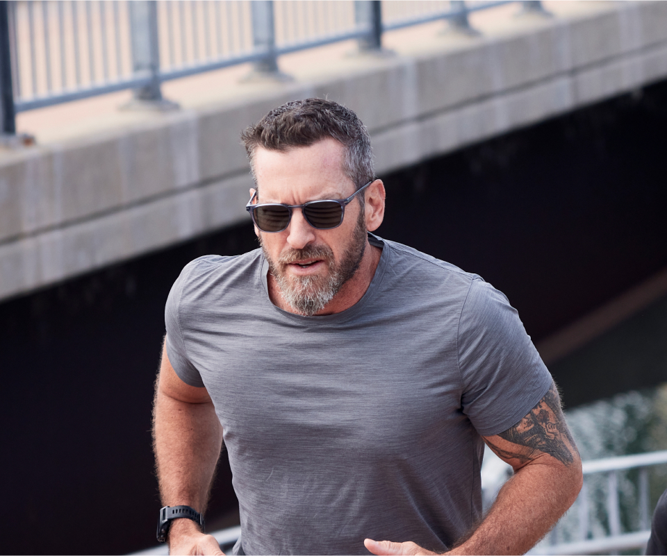 Man jogging on bridge wearing Cade sunglasses