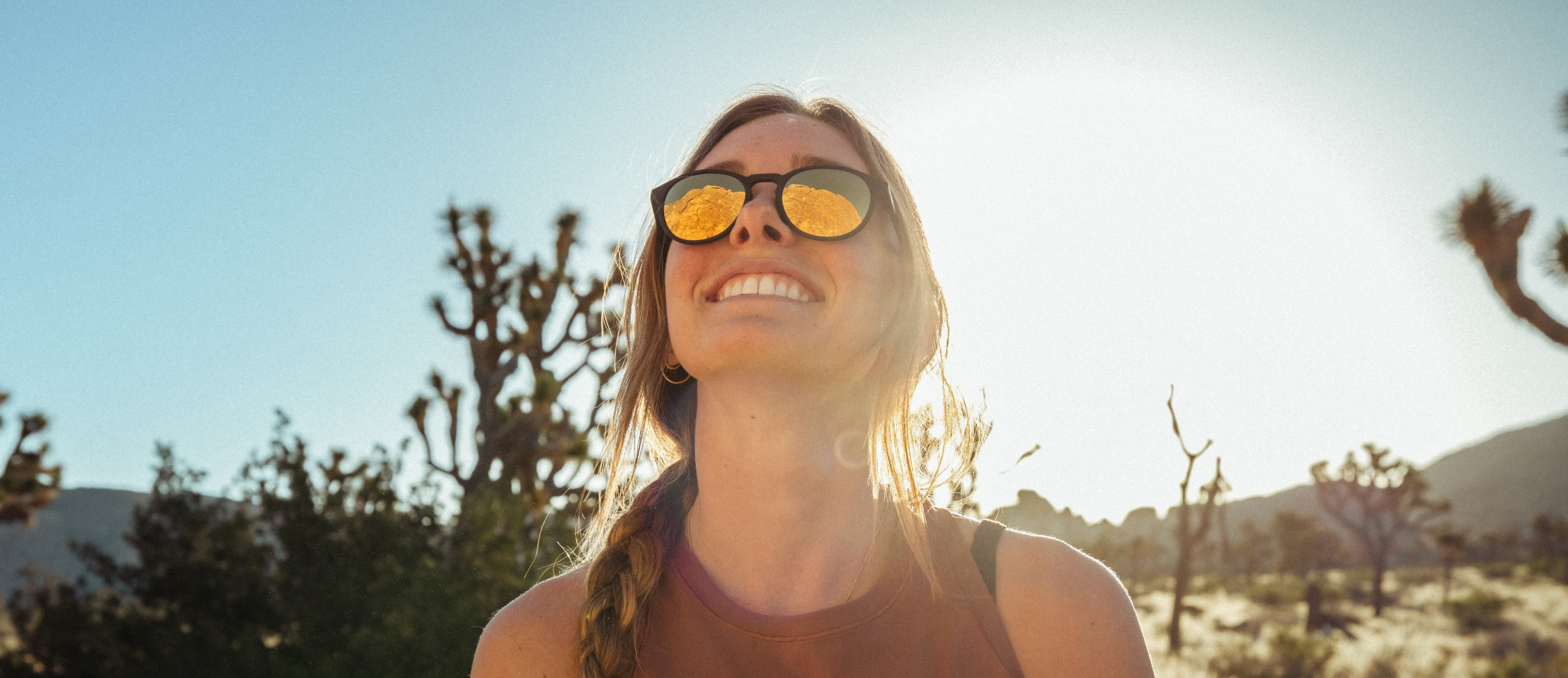 Woman smiling in desert wearing Oslo sunglasses