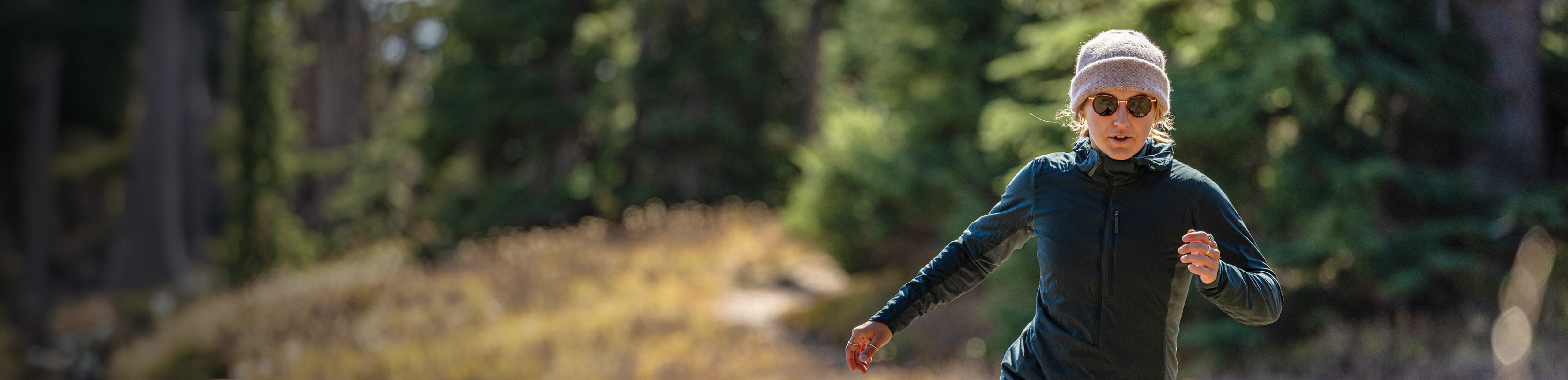 Woman running in woods wearing Alto fusion Sunglasses