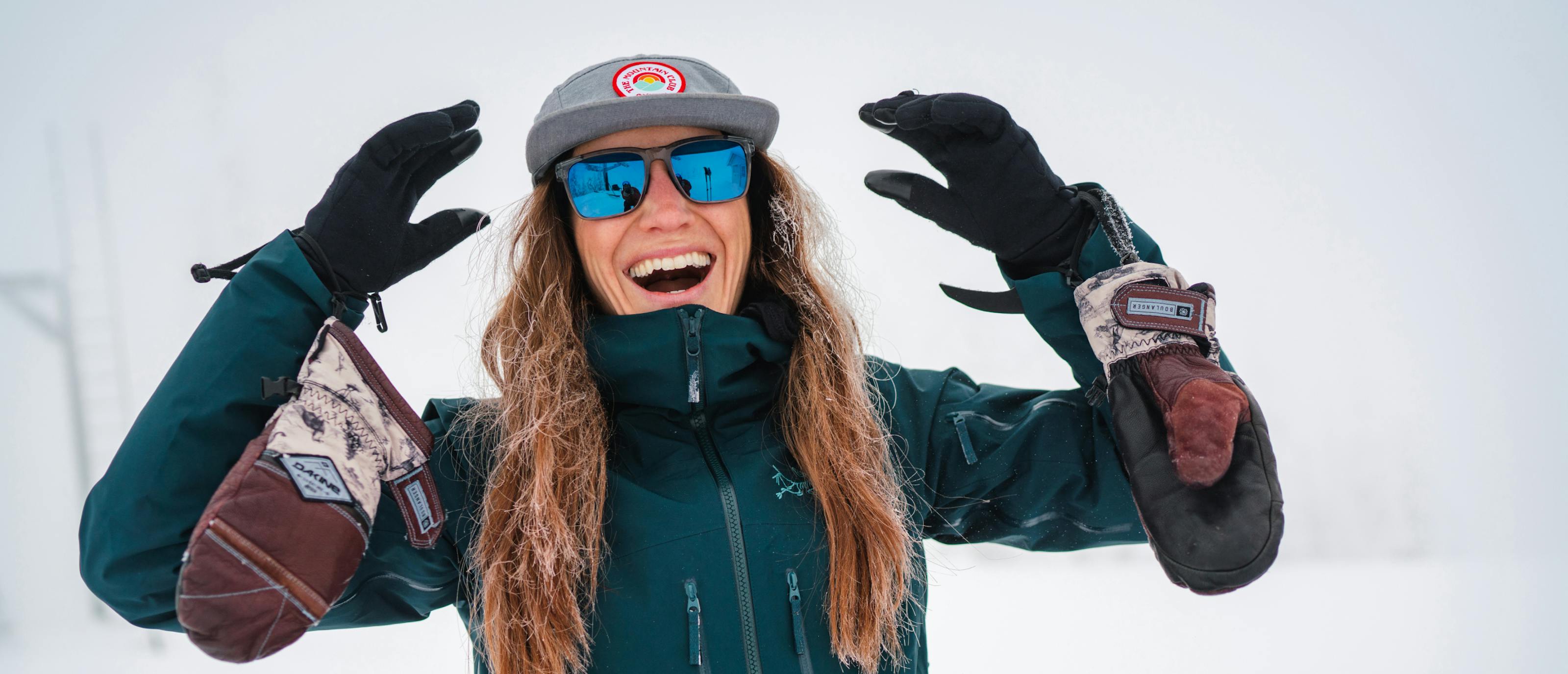 Woman smiling in the snow wearing Barton sunglasses