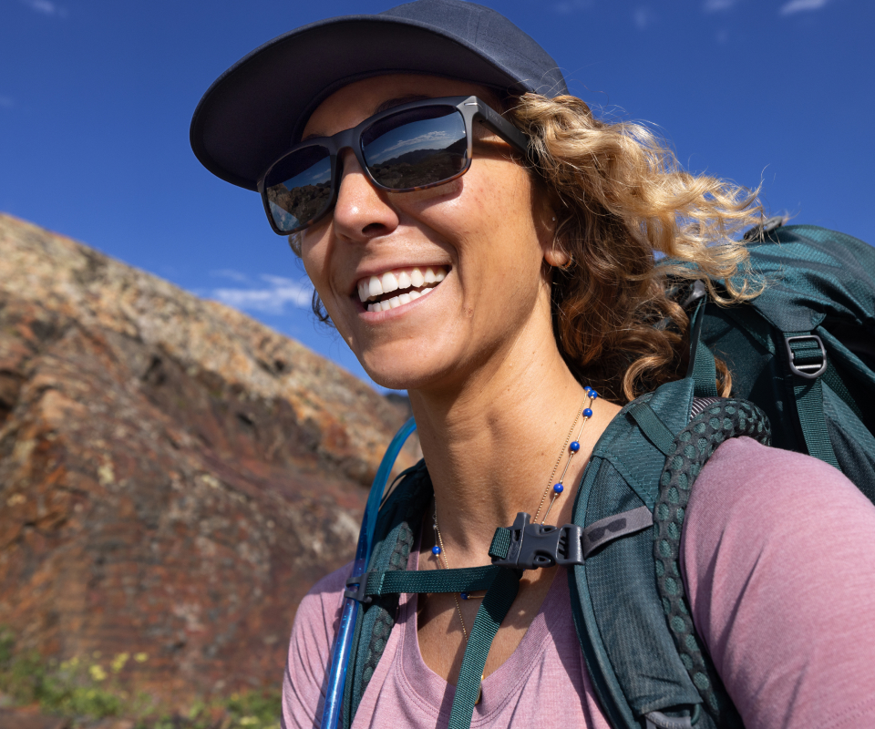 Man hiking and smiling wearing Braker 2.0 sunglasses