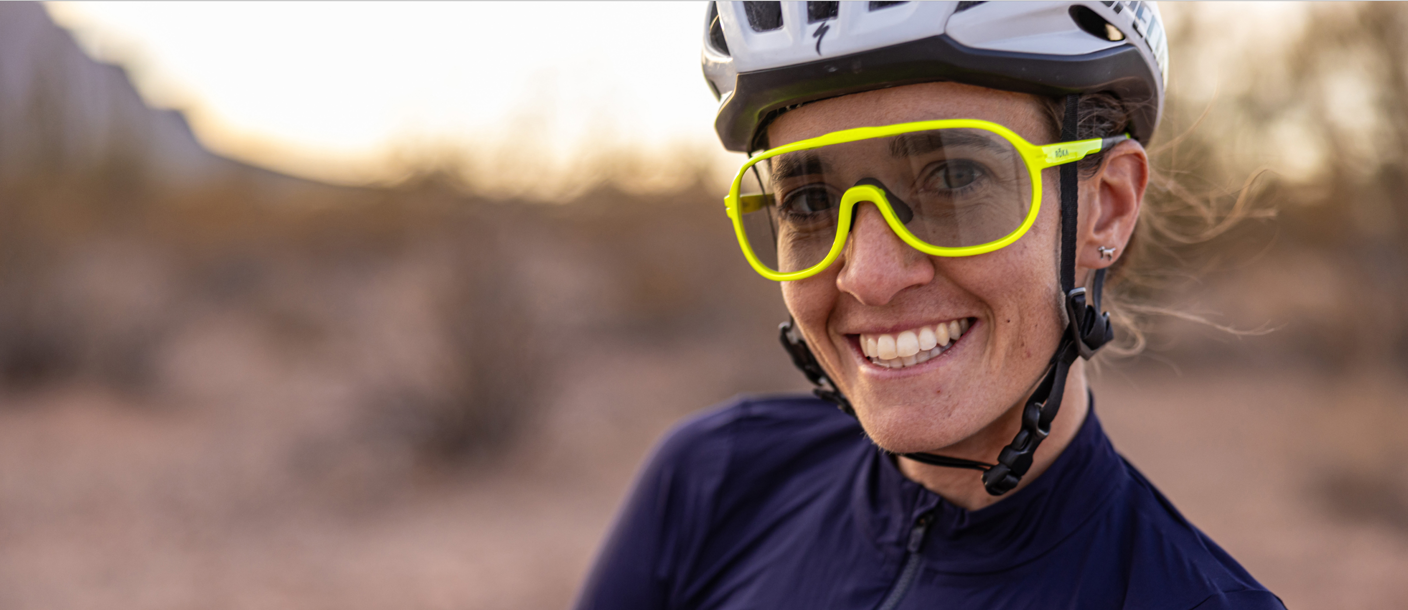 Woman smiling wearing cycling gear and San Remo glasses