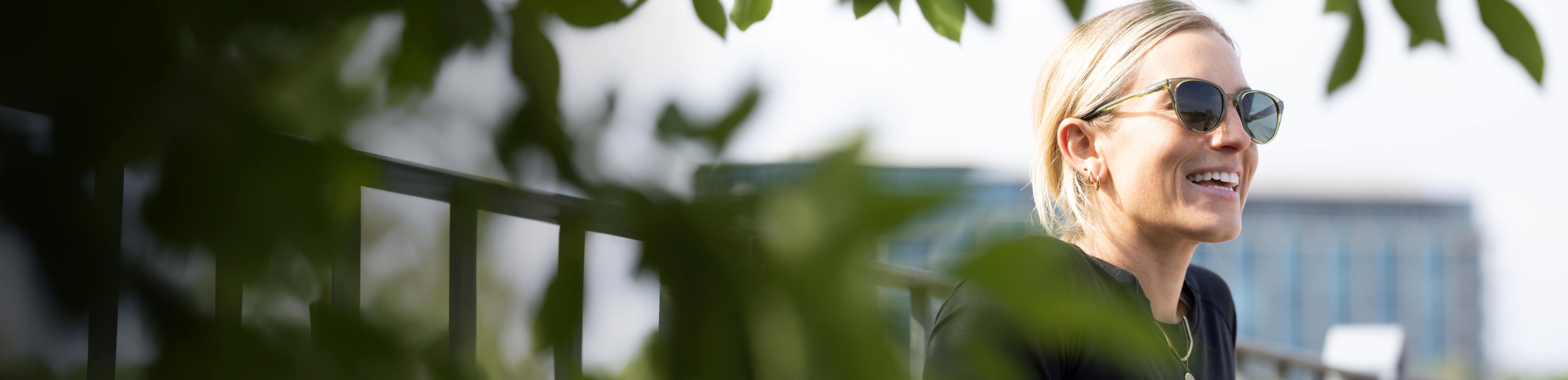 Woman smiling in green Lola sunglasses