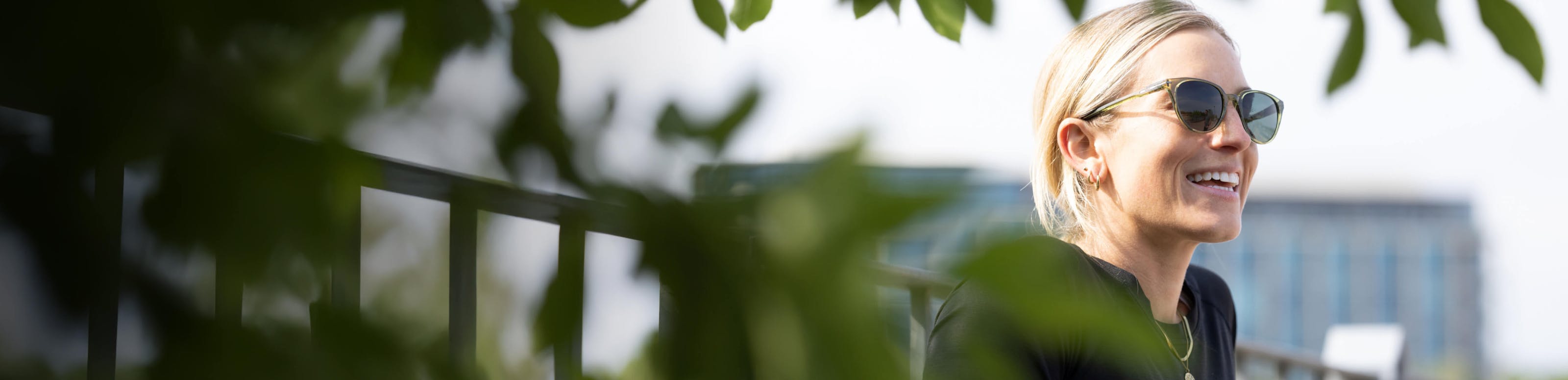 Woman smiling in green Lola sunglasses