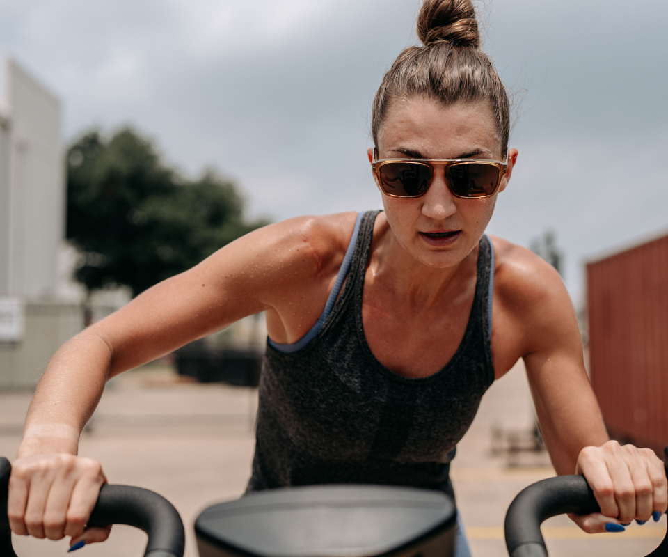 Woman riding assault bike wearing Estacado sunglasses