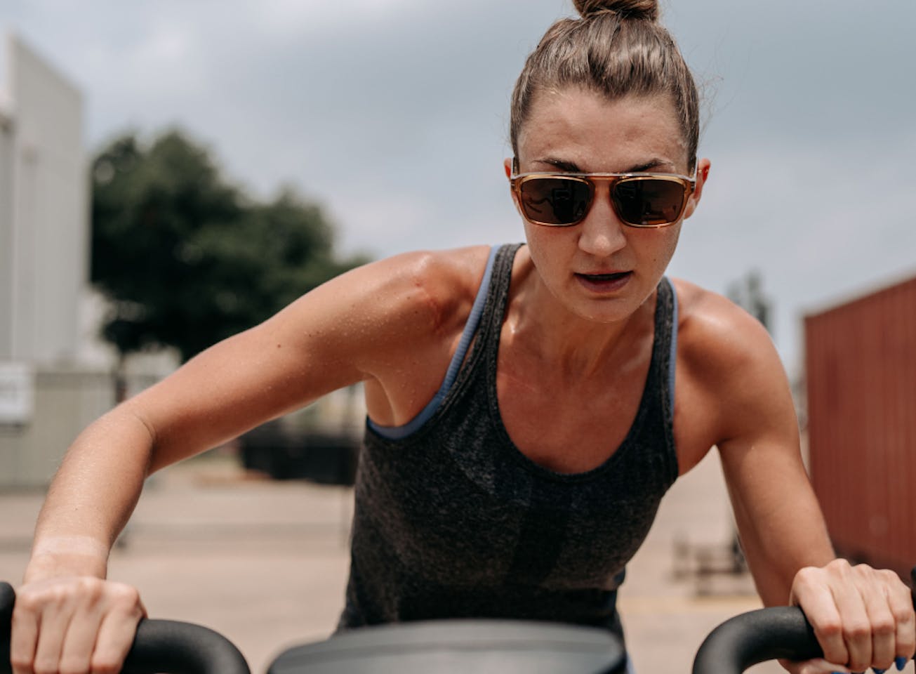 Woman riding assault bike wearing Estacado sunglasses