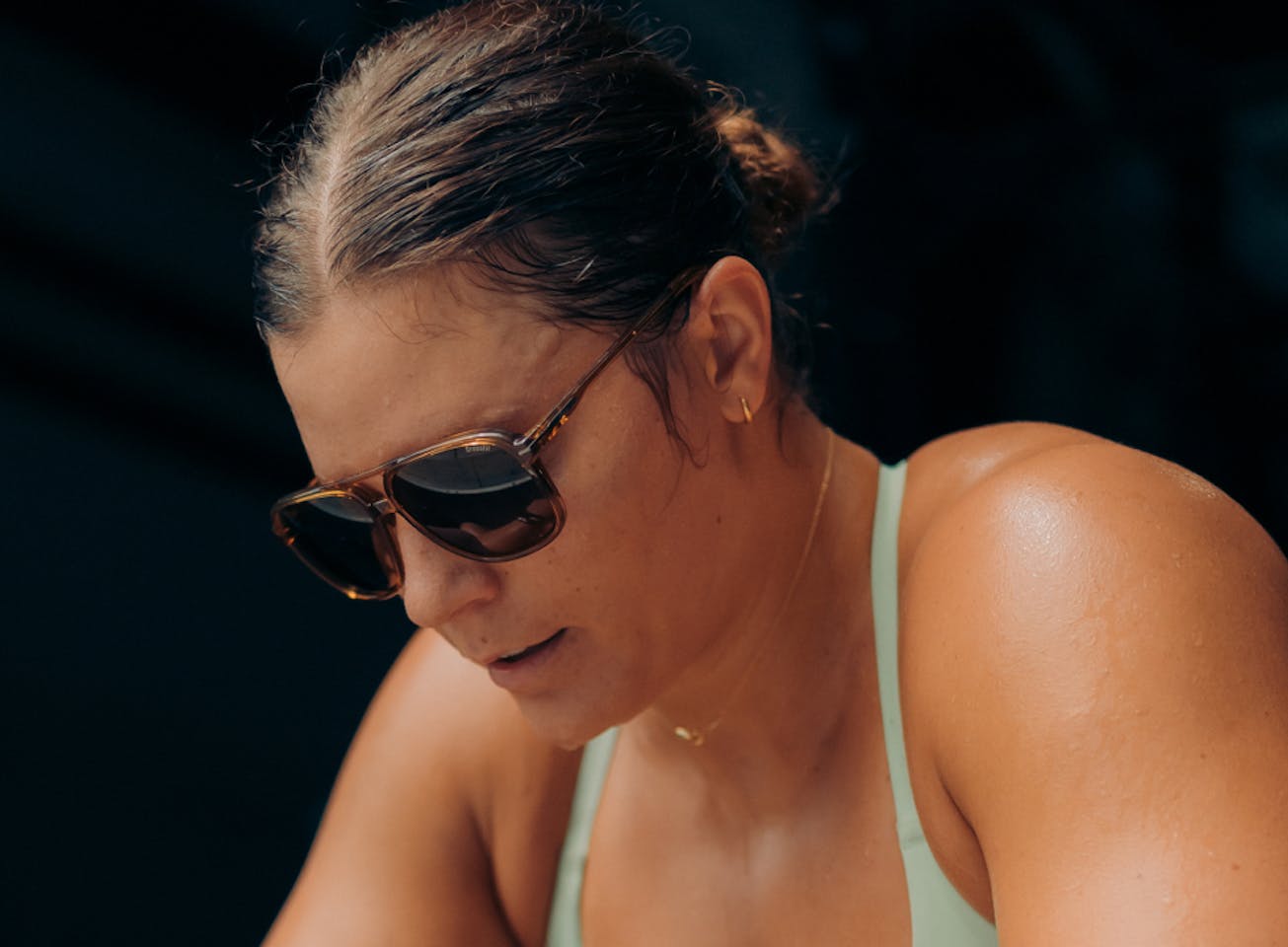 Woman wearing green tank top and Bandera sunglasses