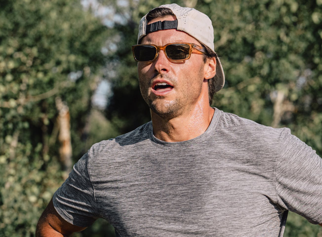 Man sweating wearing backwards hat and Mayfield sunglasses