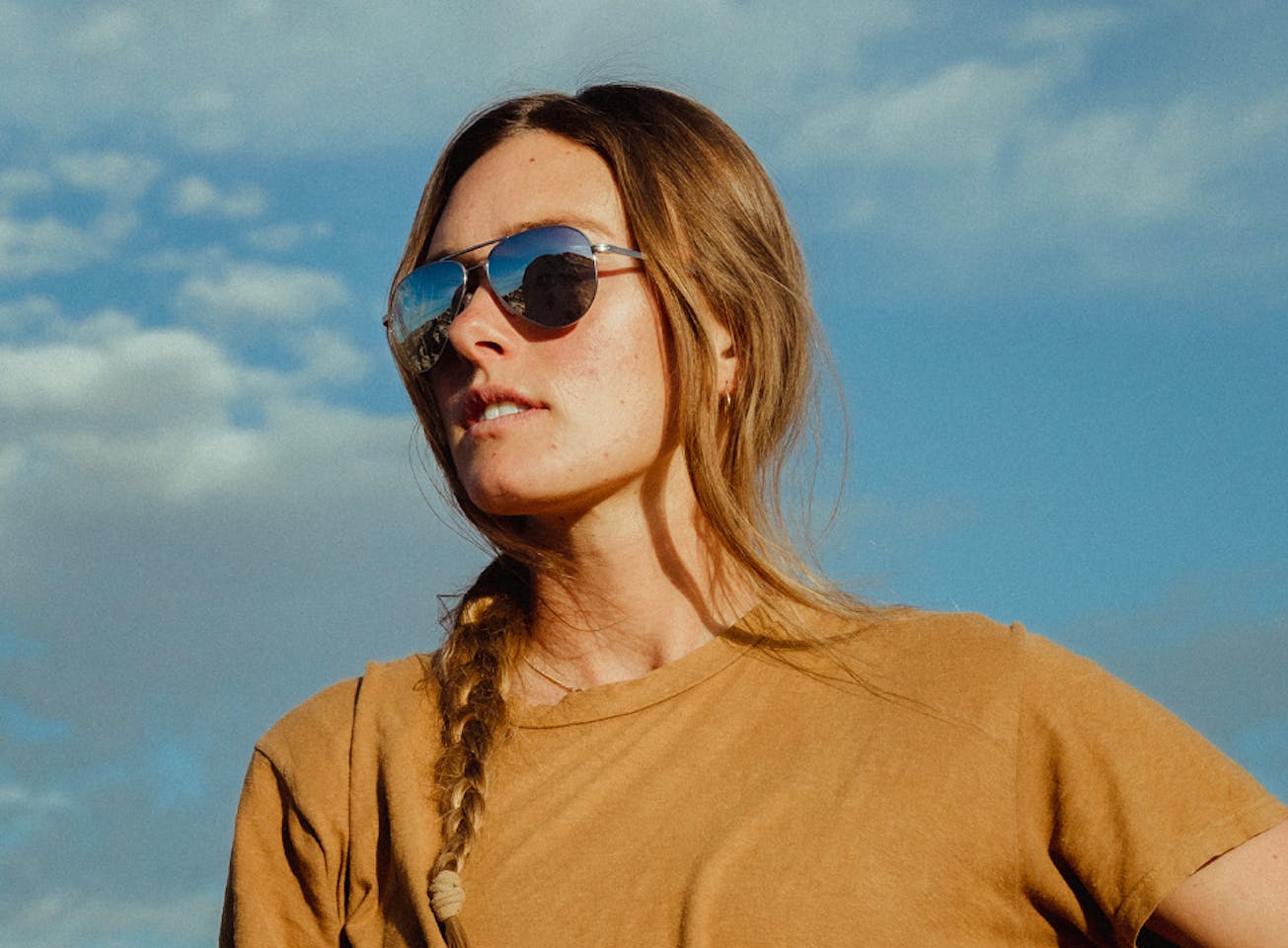 Woman wearing orange shirt and Phantom mirrored sunglasses