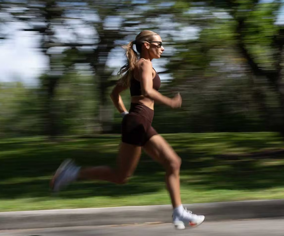 Woman running in woods in Havana sunglasses