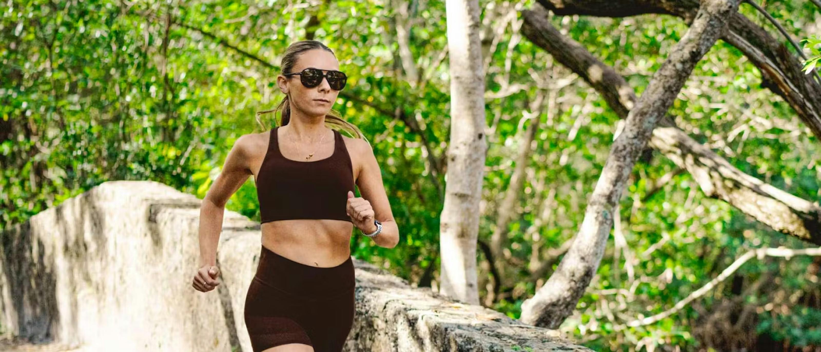 Woman running in woods in Havana sunglasses