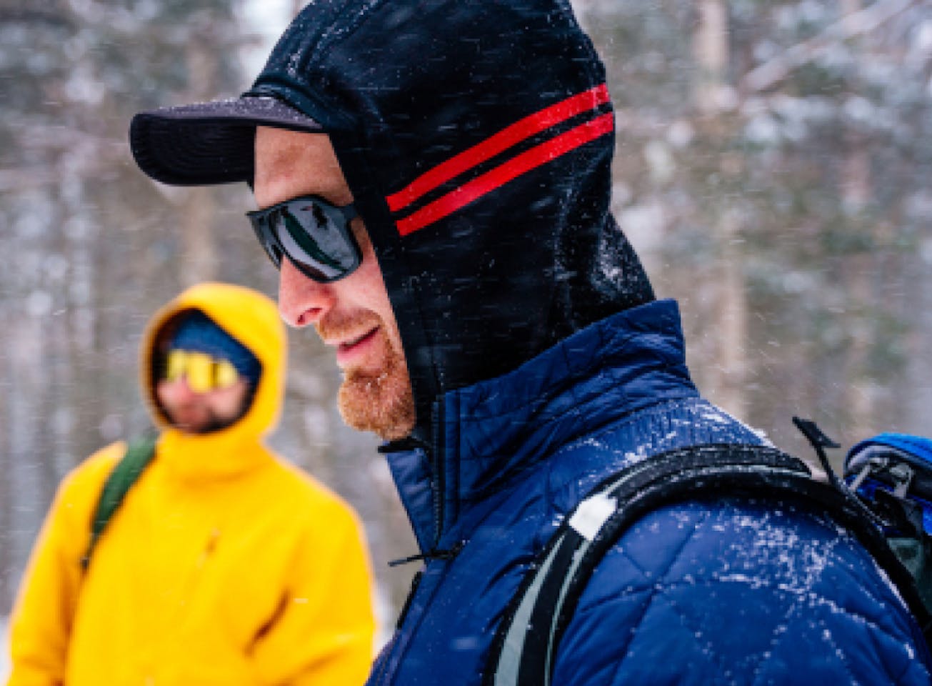 Man in snow wearing hoodie and Torino sunglasses
