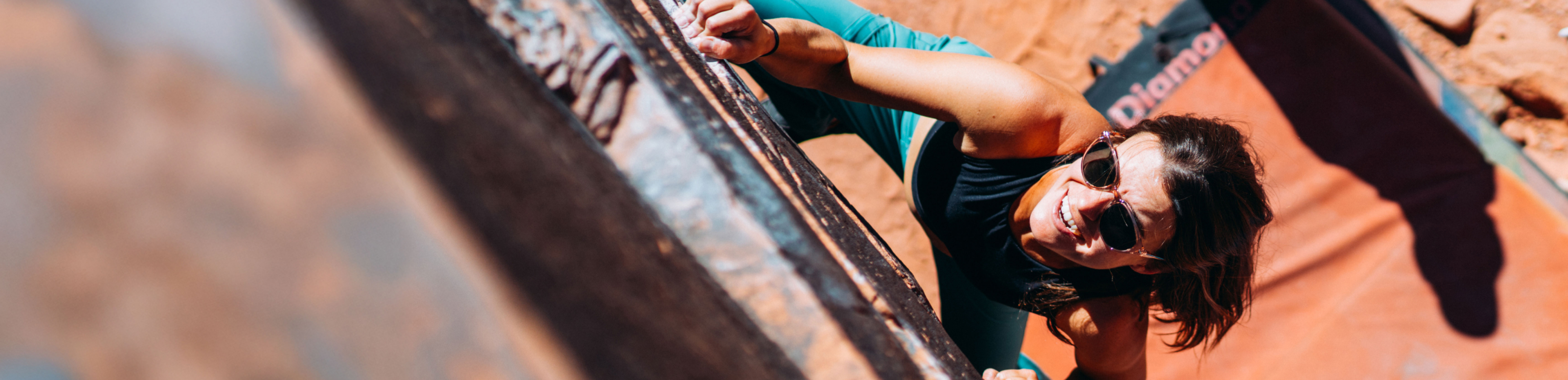 Woman rock climbing in Lola sunglasses