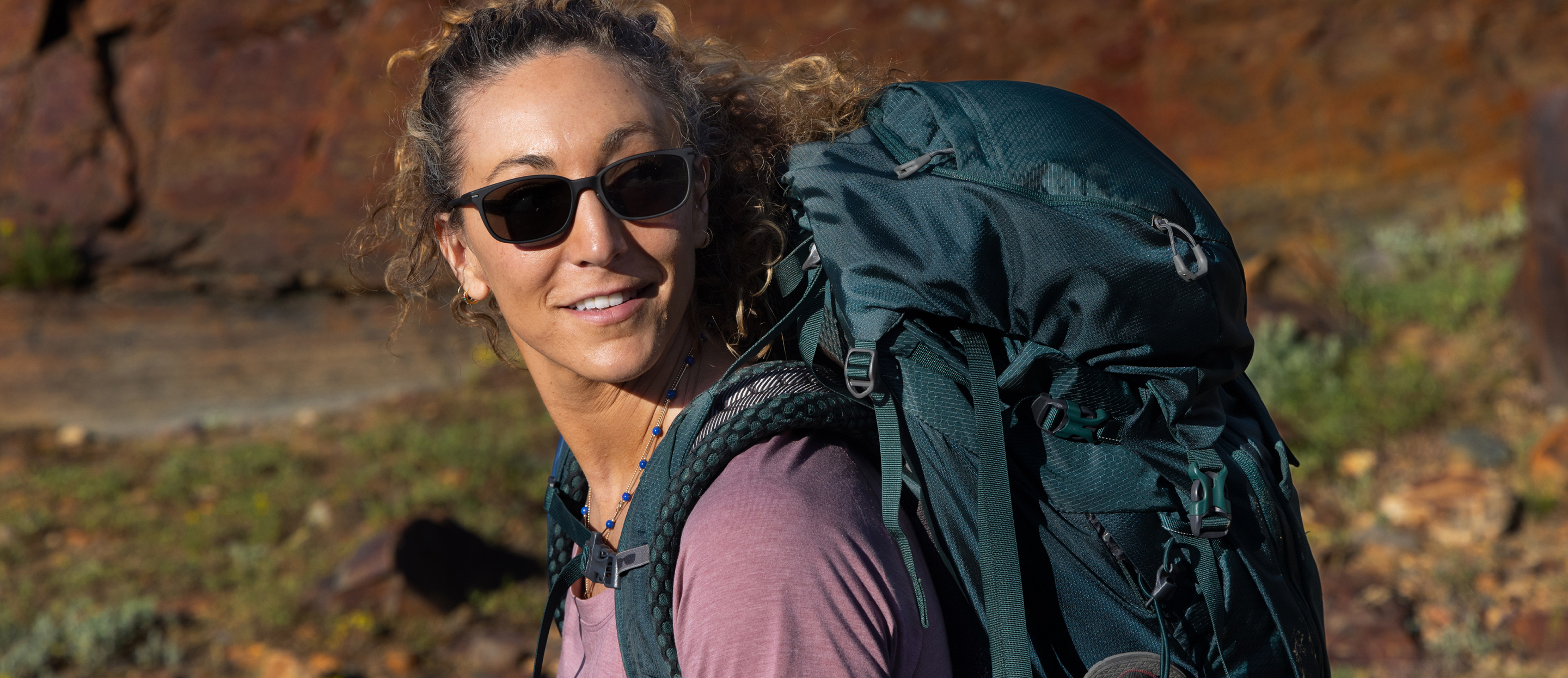 Woman backpacking in Palmer sunglasses