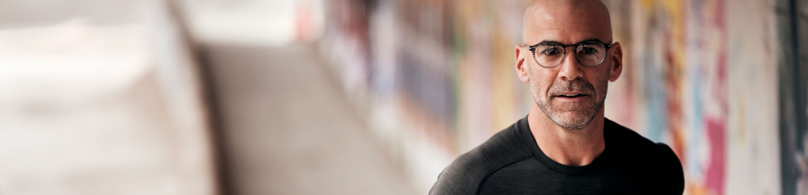 Man jogging wearing black shirt and ROKA glasses