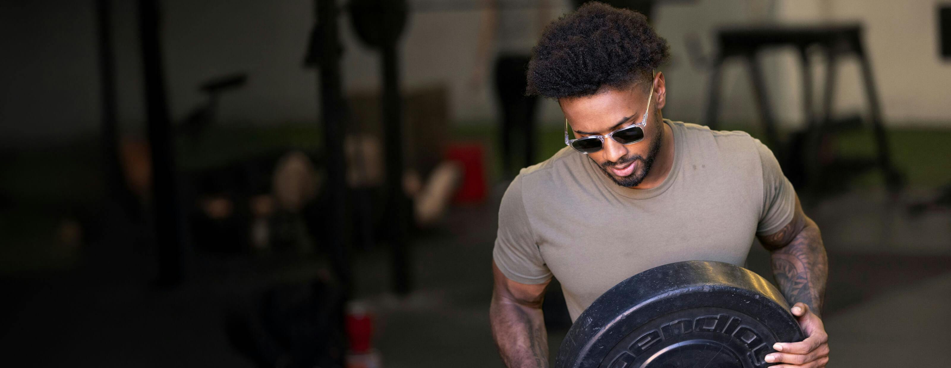 Man carrying weight wearing ROKA sunglasses