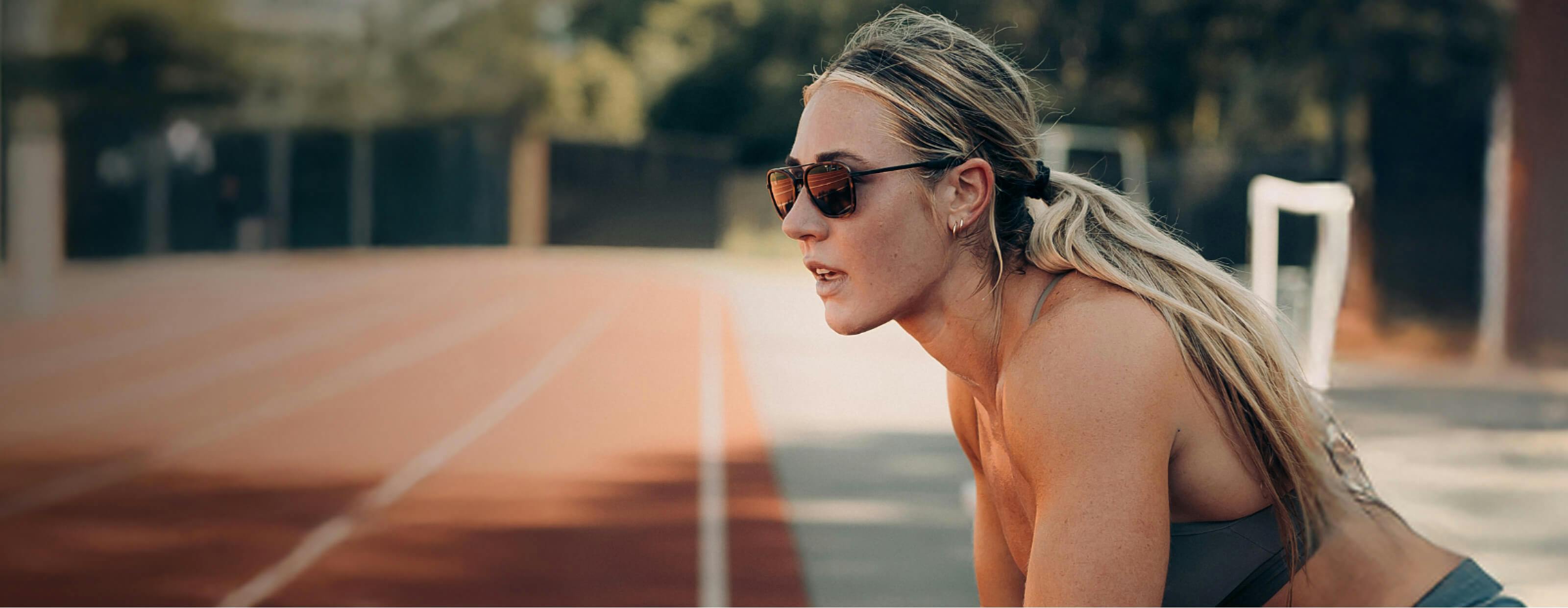 Woman on running track wearing ROKA sunglasses