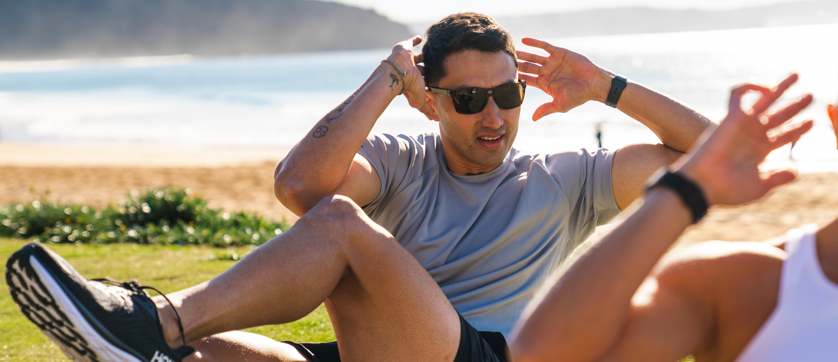 Man doing crunches wearing Kona Sunglasses