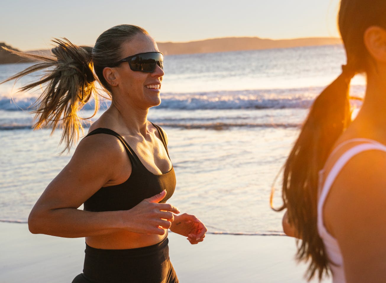 Woman jogging on beach wearing CP-1x sunglasses