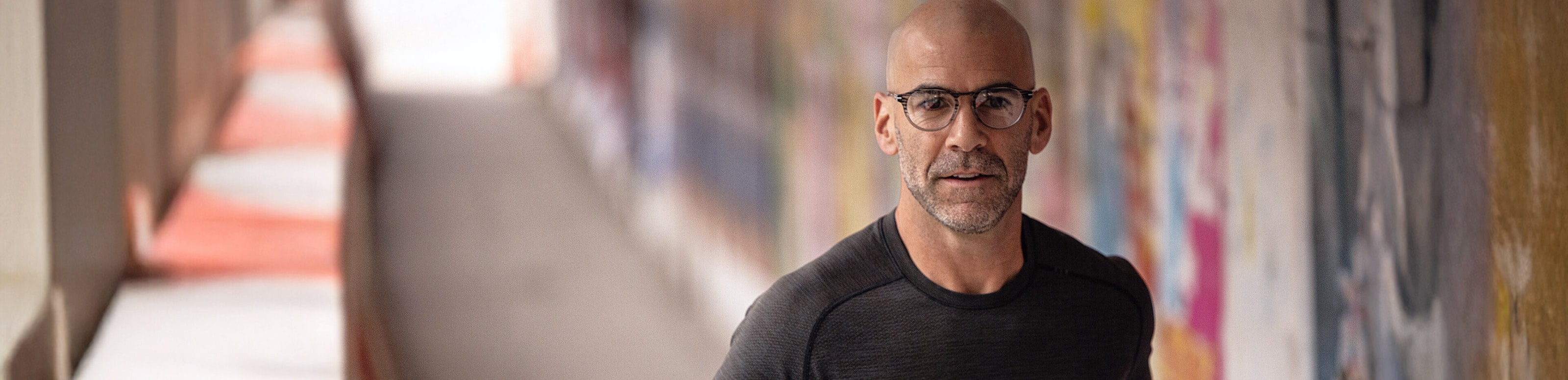 Man jogging wearing black shirt and ROKA glasses