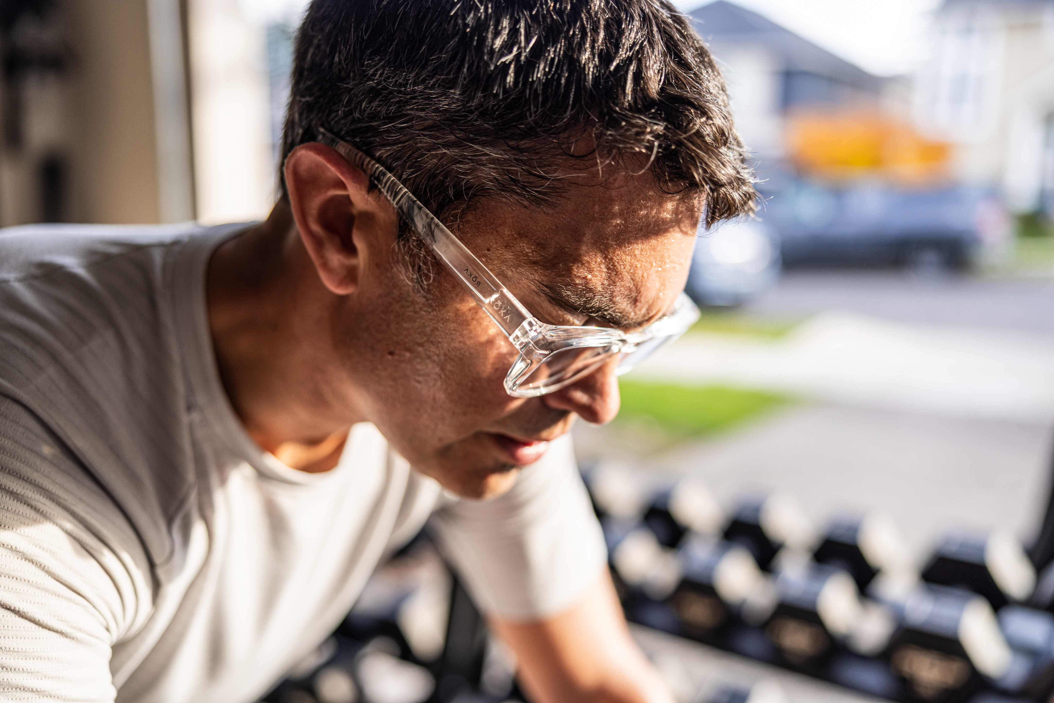 Man riding stationary bike with reading glasses on.