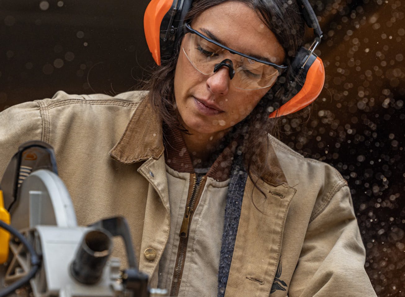 Woman with chainsaw cutting wood wearing ROKAs