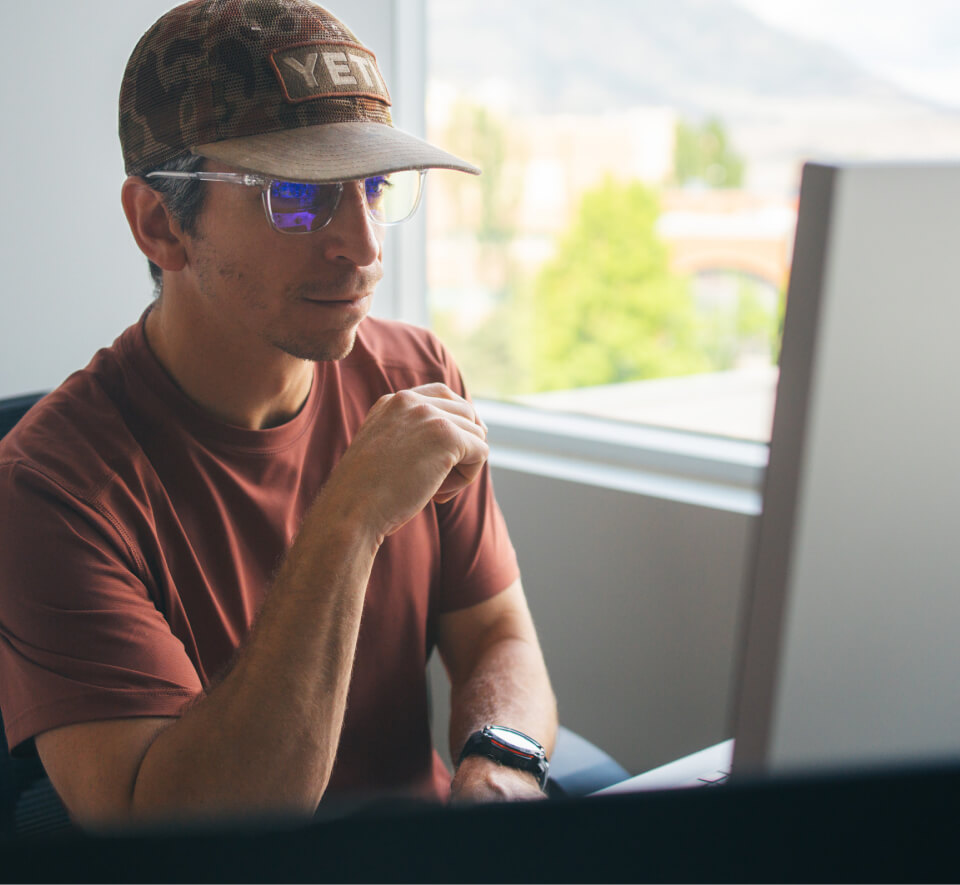 Man on computer using blue light blocking glasses