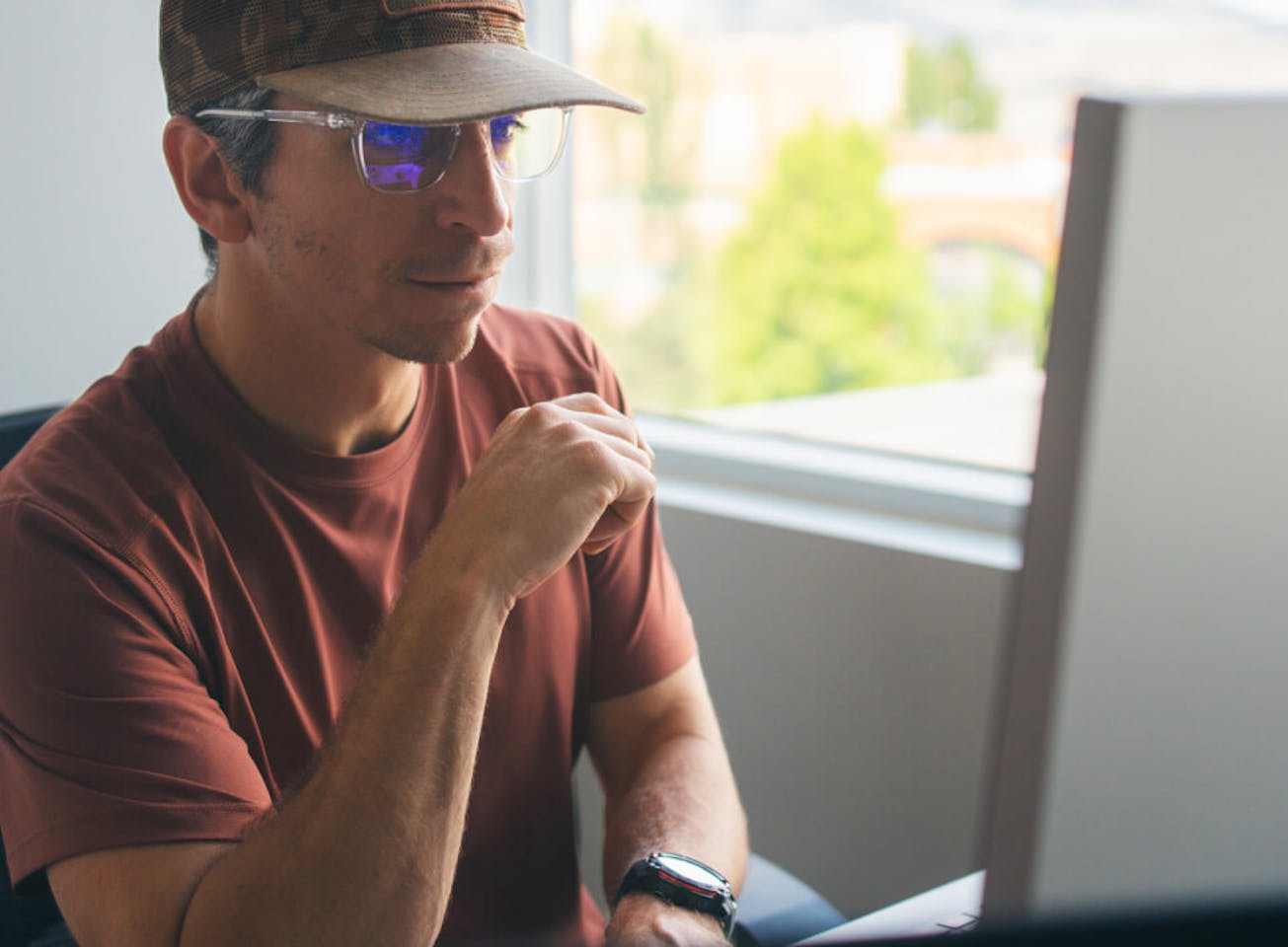Man on computer using blue light blocking glasses