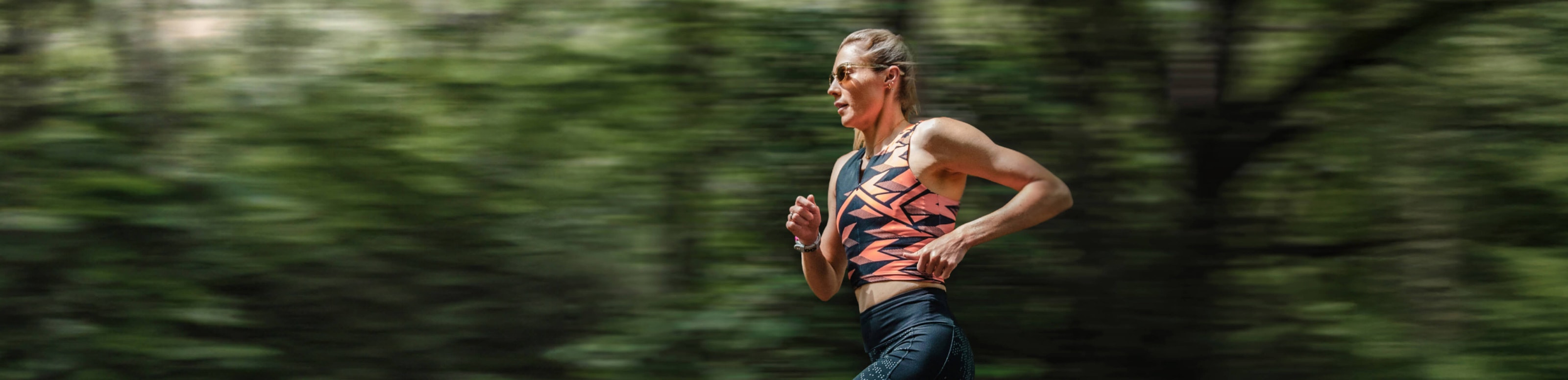 Woman running through woods in ROKA sunglasses