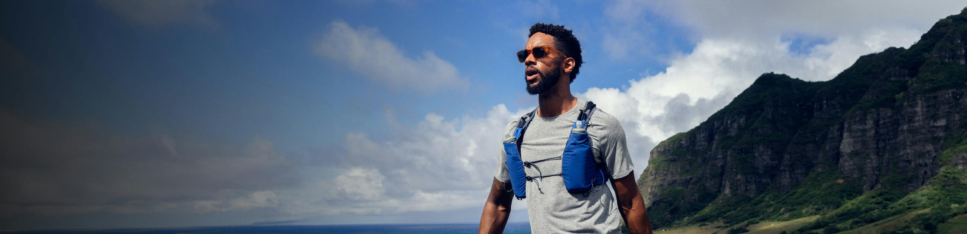 Man hiking mountains wearing ROKA sunglasses