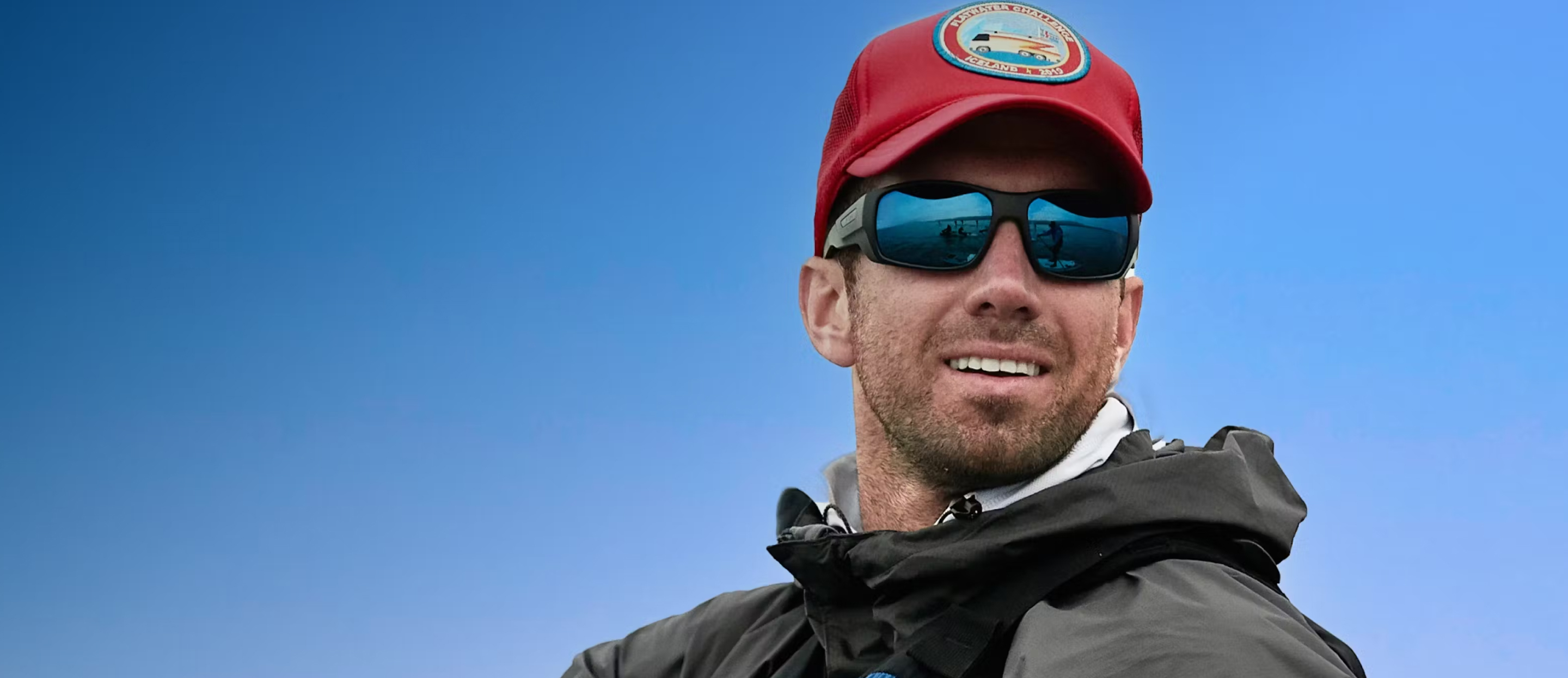 Man wearing  red hat and ROKA blue mirror sunglasses
