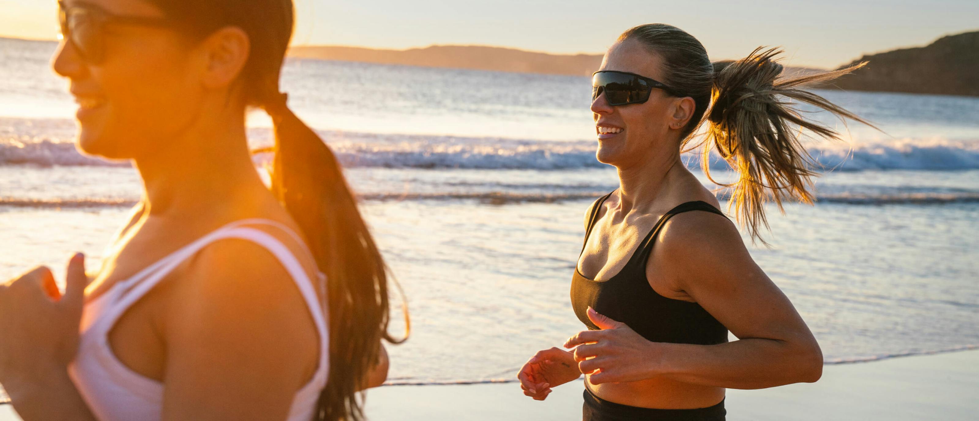 Women jogging on beach wearing ROKA sunglasses