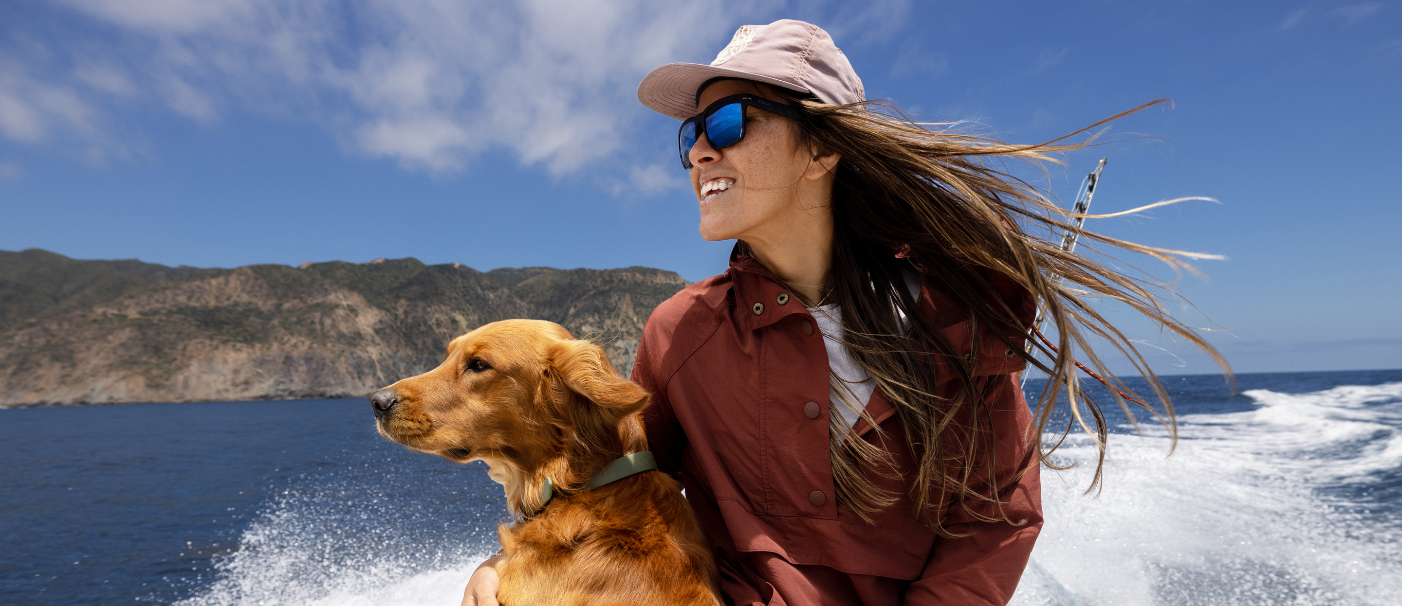Woman riding on boat with dog wearing Barton sunglasses